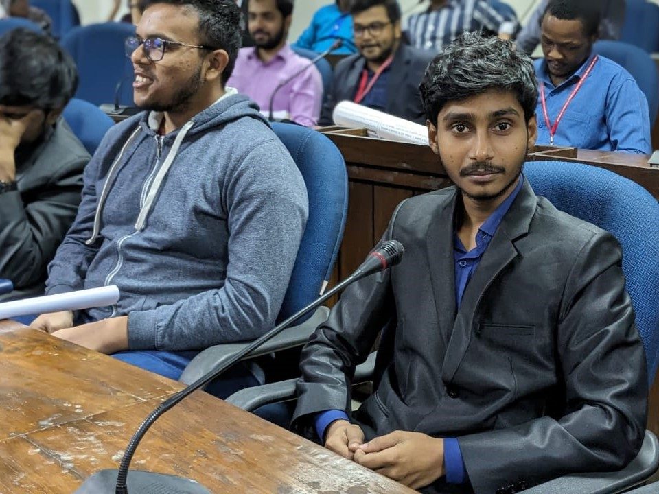 Seated at a microphone during a conference session